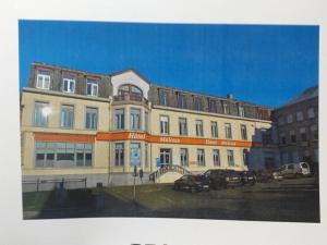 a large building with cars parked in a parking lot at hotel Melissa in Péruwelz