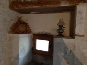 una piccola finestra nell'angolo di una stanza di Wisteria Cottage a Les Adjots