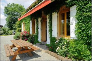 a wooden bench sitting outside of a building at Gîte des Grands Narreaux in Bourbon-Lancy