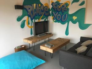 ein Wohnzimmer mit einem TV, einem Sofa und einem Tisch in der Unterkunft Gîte PLACE FOR YOU in Malissard