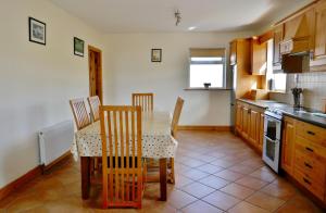 uma cozinha com uma mesa e cadeiras numa cozinha em Cois Farraige em Doolin