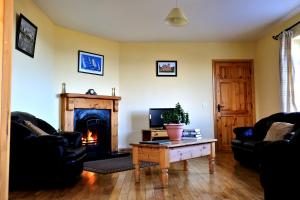 a living room with a fireplace and a table at Cois Farraige in Doolin