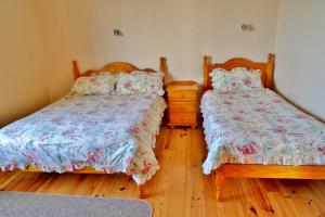 a bedroom with two beds and a wooden floor at Cois Farraige in Doolin