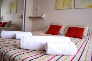 a room with two beds with white blankets and red pillows at Sweet Home Olivares in Olavarría +19 photos