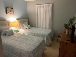 Terra Verde Vacation Rentals في كيسيمي: غرفة نوم بسريرين ومصباح ونافذة