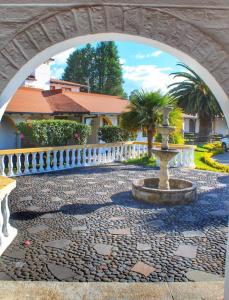 a stone walkway with a white fence and a fountain at Hosteria San Carlos Tababela in Tababela