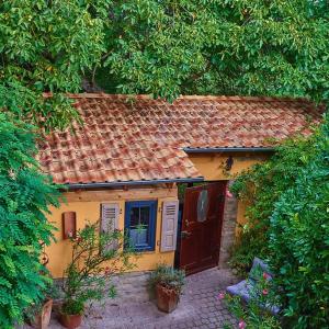 a small yellow house with a red roof at Biggi‘s Garten-Finca in Flonheim