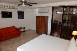 sala de estar con cama y sofá en La Posada del Arcangel en Managua