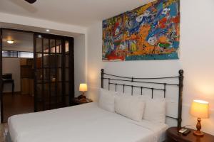 ein Schlafzimmer mit einem Bett und einem Wandgemälde in der Unterkunft La Posada del Arcangel in Managua