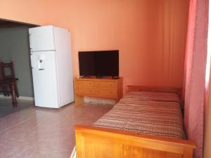 Habitación pequeña con nevera y TV. en Casa vista al Rio Parana Vuelta de Obligado en San Pedro