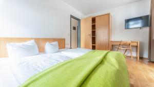 Un dormitorio con una cama con una manta verde. en Appartement Berge, en Sankt Anton am Arlberg