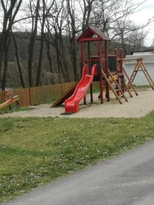 un parque infantil con un tobogán rojo en un parque en Mobilheim 16 a 17 - Výrovická přehrada Výr, en Výrovice