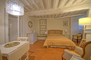 um quarto com uma cama, uma mesa e cadeiras em Castello di Montegufoni by PosarelliVillas em Montagnana Val di Pesa