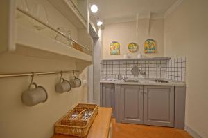 a kitchen with a counter and a sink and a table at Castello di Montegufoni by PosarelliVillas in Montagnana Val di Pesa