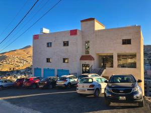 a parking lot with cars parked in front of a building at Rakan ApartHotel and Luxury Rooms in Wadi Musa