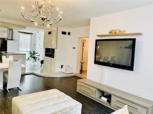 sala de estar con TV de pantalla plana en la pared en Apartamenty VIP, en Ustka