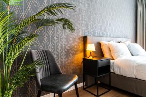 a bedroom with a bed and a chair and a plant at Hotel Brasserie de Huifkar in Middelburg