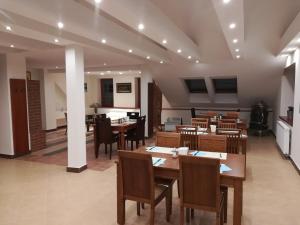 a dining room with wooden tables and chairs at Hotel na Kafkové in Ostrava