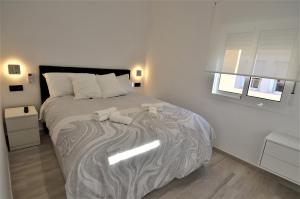 a bedroom with a bed with two towels on it at ATICO DE LUJO EN EL CENTRO HISTÓRICO in Málaga