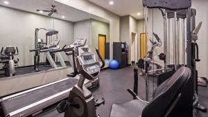 un gimnasio con dos máquinas de correr y un espejo en Chicago Southland Hotel, en Oak Forest