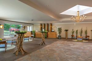 a lobby with tables and chairs and a chandelier at Best Western Hotel Mainz in Mainz