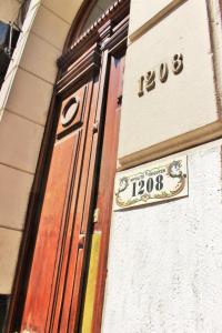 une porte menant à un bâtiment avec un panneau sur celui-ci dans l'établissement DEL900 Hotel Boutique, à Buenos Aires