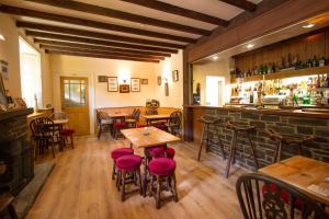 a restaurant with wooden tables and chairs and a bar at Polraen Country House Hotel in Looe