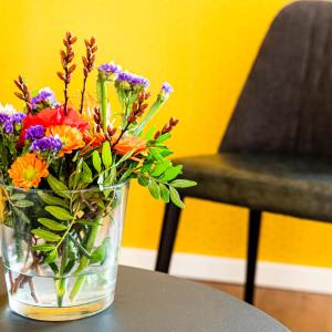 un vaso di fiori seduto su un tavolo di Hotel Brasserie de Huifkar a Middelburg