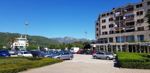 a parking lot with cars parked in front of a building at Apartman "Lara" in Ploče