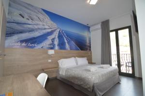 陶爾米納的住宿－卡薩克瓦亞公寓，一间卧室配有一张壁画大床