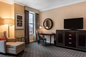 a hotel room with a flat screen tv and a desk at Omni Severin Hotel in Indianapolis