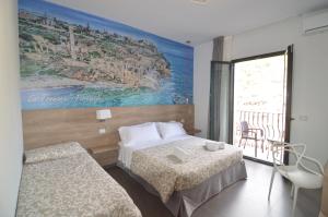 a hotel room with two beds and a painting on the wall at Casa Corvaja in Taormina