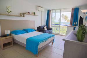 ein Schlafzimmer mit einem Bett und einer Couch und einem Fenster in der Unterkunft AZUR - Séjour FARNIENTE en Guadeloupe! in Le Gosier