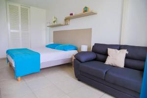 ein Wohnzimmer mit einer Couch und einem Bett in der Unterkunft AZUR - Séjour FARNIENTE en Guadeloupe! in Le Gosier