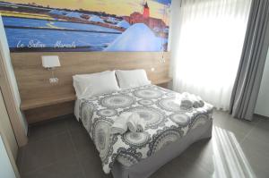 a bedroom with a bed with a painting on the wall at Casa Corvaja in Taormina