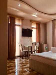 Habitación de hotel con cama, mesa y sillas en Hotel Tourist en Tiflis