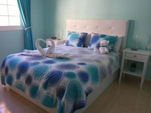 ein Schlafzimmer mit einem Bett mit zwei Schwänen darauf in der Unterkunft Laderas del Palmar in Palm-mar