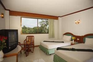 una camera d'albergo con due letti e una televisione di Boon Siam Hotel a Krabi town