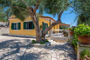 a yellow house with a tree in front of it at Villa RAXI in Plátanos