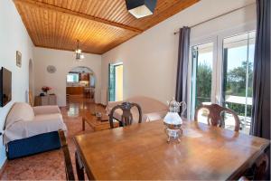 uma sala de estar com uma mesa de madeira e um sofá em Villa RAXI em Plátanos