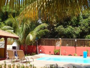 una piscina con sillas, una valla y árboles en Casas Barra Sol, en Barra Grande
