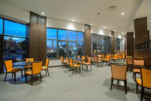 a restaurant with tables and chairs and windows at Azalaï Hôtel Bamako in Bamako