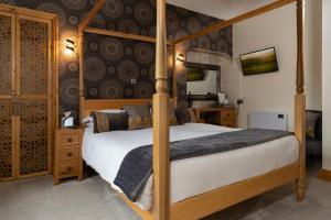 a bedroom with a four poster bed and a mirror at Melrose Guesthouse in Ambleside