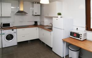 a kitchen with white cabinets and a washer and dryer at Apartamento Turistico Puente Romano P4 2-A in Salamanca