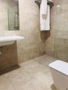 a bathroom with a toilet and a sink and a mirror at Apartamento Turistico Puente Romano P4 2-A in Salamanca +4 photos
