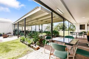 un patio al aire libre con mesa y sillas en Comfort Inn Parklands Calliope, en Calliope