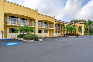 un gran edificio amarillo con palmeras en un aparcamiento en Comfort Inn Sun City Center - Ruskin - Tampa South, en Sun City Center