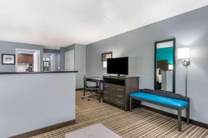 Una habitación de hotel con un escritorio y un televisor. en Comfort Inn Sun City Center - Ruskin - Tampa South, en Sun City Center