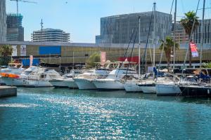 a group of boats docked in a marina in a city at Boat Accommodations Barcelona in Barcelona