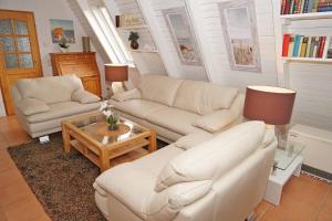 a living room with two couches and a coffee table at Zeltdachhaus mit TV im Schlafzimme in Damp